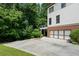 House exterior featuring a garage and a large driveway surrounded by trees at 1215 Renaissance Se Ct, Mableton, GA 30126