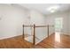 This hallway features hardwood floors and staircase with white and wooden rails at 1215 Renaissance Se Ct, Mableton, GA 30126