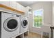 Laundry room with a white sink, washer and dryer, and a view of the outside at 1215 Renaissance Se Ct, Mableton, GA 30126