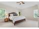 This bedroom features carpet floors, ceiling fan, and windows with view of surrounding trees at 1215 Renaissance Se Ct, Mableton, GA 30126