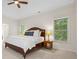 The bedroom features carpet, ceiling fan, and windows with view to surrounding trees at 1215 Renaissance Se Ct, Mableton, GA 30126