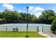 Outdoor tennis court enclosed by a fence, trees in background and a bench for seating at 1215 Renaissance Se Ct, Mableton, GA 30126