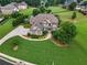 Aerial view of a luxurious home with lush landscaping, a circular driveway, and a well-manicured lawn at 2602 Alcovy Club Dr, Dacula, GA 30019