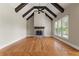 Spacious living room with a stone fireplace, wooden beams, and large windows providing natural light at 2602 Alcovy Club Dr, Dacula, GA 30019