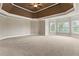 Spacious Primary bedroom featuring tray ceilings, recessed lighting, and large windows for ample natural light at 2602 Alcovy Club Dr, Dacula, GA 30019