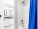Bright bathroom featuring white cabinets, marble countertop, tiled shower, and blue shower curtain at 8073 Ridge Vly, Woodstock, GA 30189