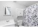 Cozy bathroom featuring vanity, commode, storage cabinet, mirror, and floral shower curtain at 8073 Ridge Vly, Woodstock, GA 30189