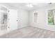 Bedroom with neutral carpeting, natural light, window blinds, and paneled door leading into hallway at 8073 Ridge Vly, Woodstock, GA 30189