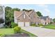 Brick home featuring manicured front yard, driveway, two-car garage, and dormer windows at 8073 Ridge Vly, Woodstock, GA 30189