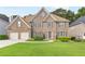 Beautiful two-story brick home boasts a well-manicured lawn and a two-car garage at 8073 Ridge Vly, Woodstock, GA 30189