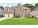 Charming brick home featuring a well-manicured lawn and a two-car garage at 8073 Ridge Vly, Woodstock, GA 30189
