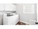 Bright laundry room with washer, dryer, and overhead cabinet storage at 8073 Ridge Vly, Woodstock, GA 30189