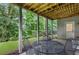 Covered patio featuring iron table and chairs, ceiling rafters, and wooded backyard at 8073 Ridge Vly, Woodstock, GA 30189