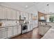 Well-lit kitchen boasts granite counters, stainless appliances, and dark wood flooring at 217 Springs Xing, Canton, GA 30114