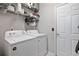 Bright laundry room with white washer and dryer, and storage shelves with supplies at 217 Springs Xing, Canton, GA 30114