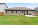 Backyard view featuring a home with brown siding, a concrete patio, and a grass lawn at 2844 Bluestone Sw Dr, Atlanta, GA 30331