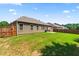 Spacious backyard with lush green lawn, a home with brown siding, and a wooden fence at 2844 Bluestone Sw Dr, Atlanta, GA 30331