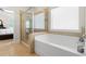 Bathroom features a tiled shower with glass door, soaking tub, and large window at 2844 Bluestone Sw Dr, Atlanta, GA 30331