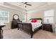 Spacious bedroom with a tray ceiling, large windows, carpet floors and a large dark wood sleigh bed and furniture at 2844 Bluestone Sw Dr, Atlanta, GA 30331