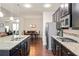 Open-concept kitchen with granite countertops, stainless steel appliances, dark cabinets, and hardwood floors at 2844 Bluestone Sw Dr, Atlanta, GA 30331