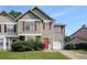 Inviting two-story townhouse featuring red shutters, a red door, and a one-car garage at 3835 Conley Downs Dr, Decatur, GA 30034