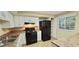 Bright kitchen features white cabinets, black appliances, and neutral countertops at 5595 Marbut Rd, Lithonia, GA 30058