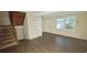Well-lit living room showcasing wood floors, an open staircase, and neutral-toned walls at 5595 Marbut Rd, Lithonia, GA 30058