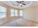 Bedroom with three bright windows, tan carpet and tray ceiling with fan at 179 Glynn Addy Dr, Stockbridge, GA 30281
