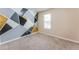 Bedroom featuring modern accent wall and natural light from window at 179 Glynn Addy Dr, Stockbridge, GA 30281