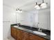 Bathroom featuring granite countertops, dark cabinetry, and a large mirror at 2108 Main Nw St, Atlanta, GA 30318