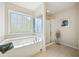 Bright bathroom featuring a large soaking tub, stand up shower, and sun-filled window at 3898 High Dove Sw Way # 12, Smyrna, GA 30082