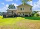 Enjoy this spacious backyard featuring a wooden deck, a lush lawn, and the exterior of a charming two-story home at 443 Rhett Dr, Loganville, GA 30052