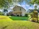 Spacious backyard featuring a two-story home, a deck, a green lawn, and a charming playset with slide at 443 Rhett Dr, Loganville, GA 30052