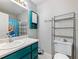 Well lit bathroom featuring turquoise painted vanity and medicine cabinet and updated fixtures at 443 Rhett Dr, Loganville, GA 30052