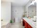 Brightly lit bathroom featuring red vanity, modern fixtures, and tile flooring at 443 Rhett Dr, Loganville, GA 30052