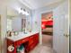 Bright bathroom features red vanity, tile floor and a door into the bedroom at 443 Rhett Dr, Loganville, GA 30052