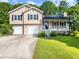 Charming home with a front porch, well-maintained lawn and two-car garage at 443 Rhett Dr, Loganville, GA 30052