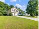 Two-story home with a two-car garage and long driveway on a sunny day at 443 Rhett Dr, Loganville, GA 30052