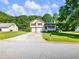 Home exterior featuring a two-car garage, well-manicured lawn and front porch at 443 Rhett Dr, Loganville, GA 30052