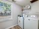 Laundry room with Maytag washer and dryer, laminate flooring and window at 443 Rhett Dr, Loganville, GA 30052