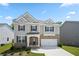 Charming two-story home with gray siding, stone accents, well-manicured lawn, and attached two-car garage at 865 Athena Bnd, Fairburn, GA 30213