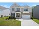 Charming two-story home with gray siding, stone accents, well-manicured lawn, and attached two-car garage at 865 Athena Bnd, Fairburn, GA 30213