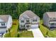 Aerial view of a two-story home featuring neutral siding, a driveway, and manicured landscaping at 865 Athena Bnd, Fairburn, GA 30213