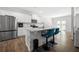 Eat-in kitchen island featuring white cabinets, stainless steel appliances and stylish seating at 865 Athena Bnd, Fairburn, GA 30213