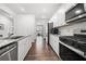 Modern kitchen with white cabinets, granite countertops, stainless steel appliances, and hardwood flooring at 865 Athena Bnd, Fairburn, GA 30213