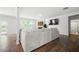 Bright living room featuring hardwood floors, large couch, views of the backyard and kitchen, and modern decor at 865 Athena Bnd, Fairburn, GA 30213