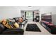 Cozy carpeted living room with large black leather sofa, throw pillows, and a large television at 865 Athena Bnd, Fairburn, GA 30213