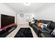 The spacious carpeted living room features a large black leather couch and television at 865 Athena Bnd, Fairburn, GA 30213