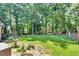 Spacious backyard featuring a lush lawn, mature trees offering shade, and plenty of room for outdoor activities at 1481 Howard Way, Lawrenceville, GA 30043