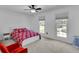 Bright bedroom with neutral carpet, red accent chair, and two windows at 1481 Howard Way, Lawrenceville, GA 30043